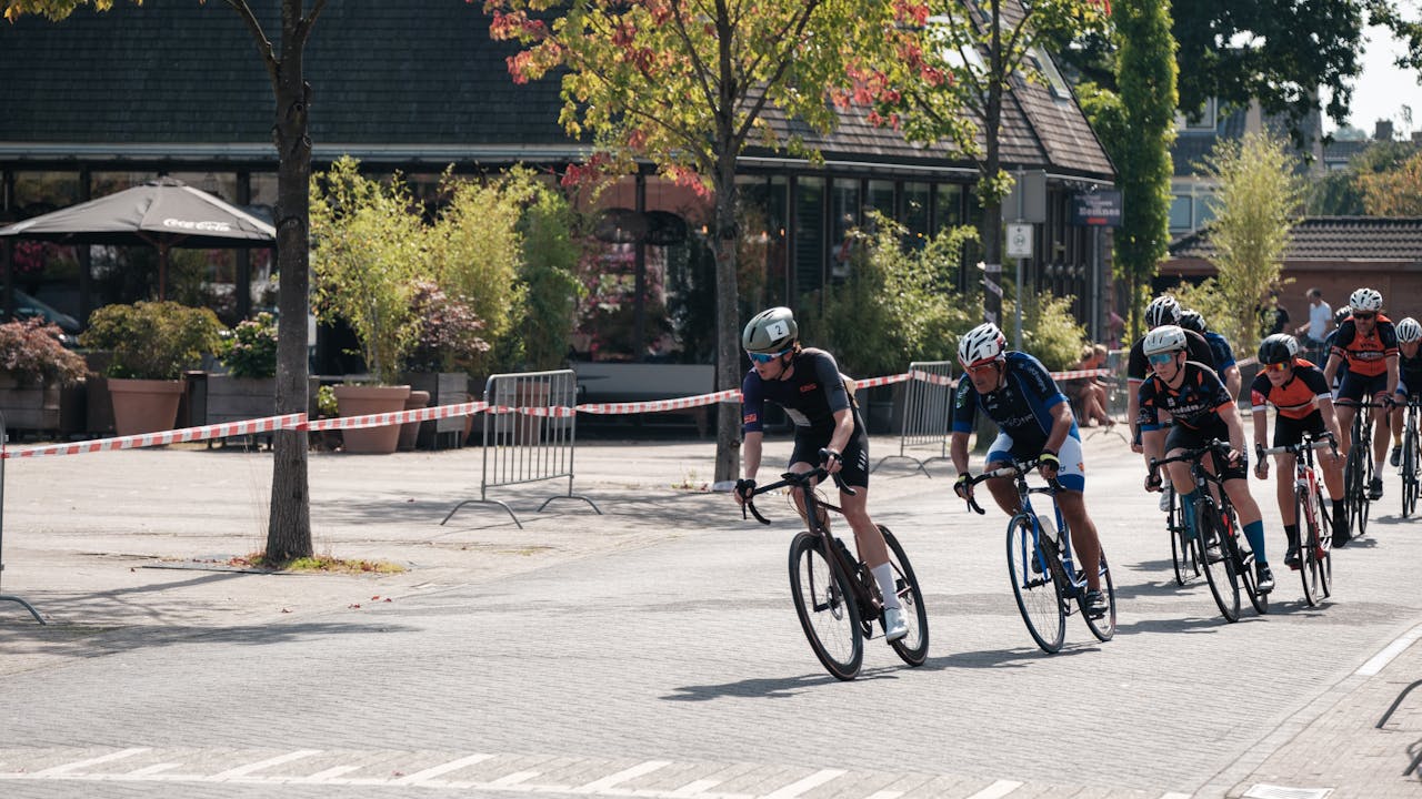 Cyclists riding in a line at high speed demonstrating the drafting and slipstreaming technique that domestiques use to shield their team leaders