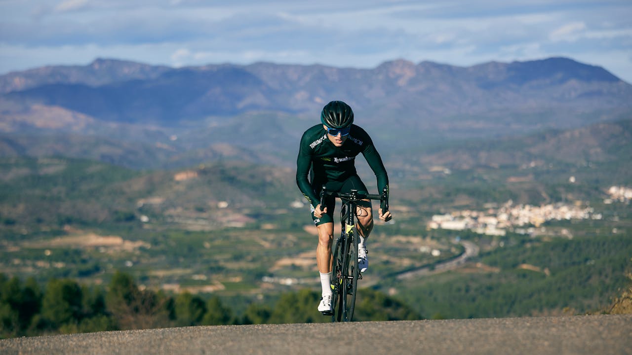 A cyclist climbing a steep mountain road, the setting where the Tour de France polka dot jersey King of the Mountains competition is decided